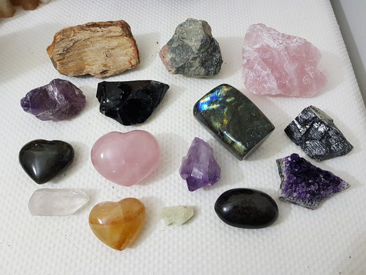 An assortment of mixed natural and polished crystals layed out on a table