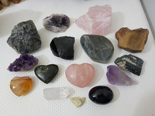 An assortment of mixed natural and polished crystals layed out on a table