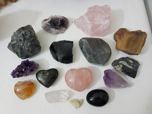 An assortment of mixed natural and polished crystals layed out on a table