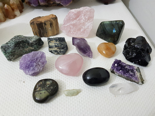 An assortment of mixed natural and polished crystals layed out on a table