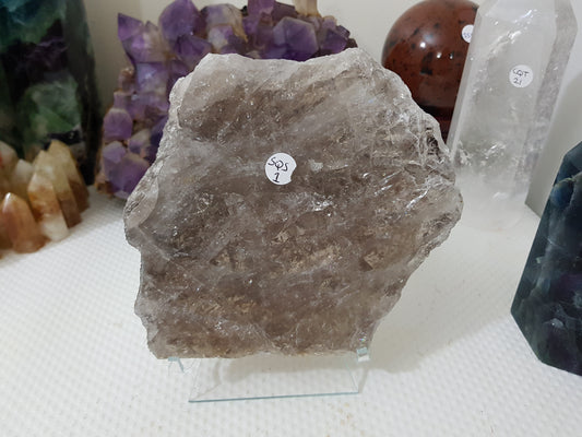 A large Smoky Quartz crystal slice that is approximately 15.5cm by 14cm in size resting on a display stand