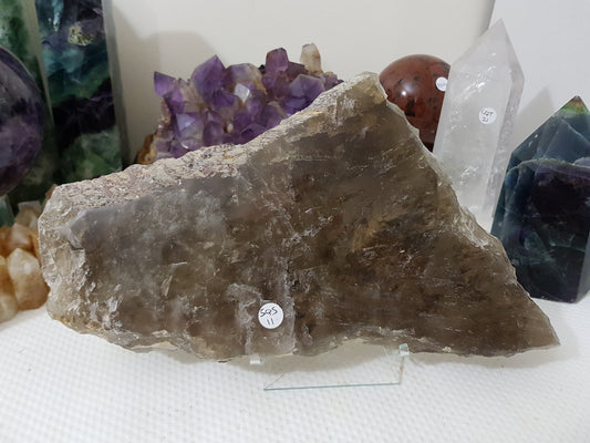 A Smoky Quartz crystal slice that is approximately 33 centimetres by 18 centimetres in size resting on a display stand