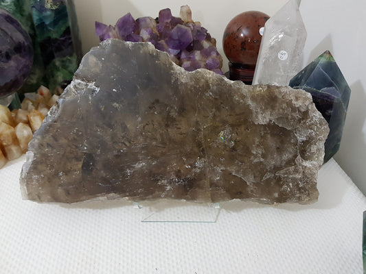 A Smoky Quartz crystal slice that is approximately 33.5 centimetres by 18 centimetres in size resting on a display stand