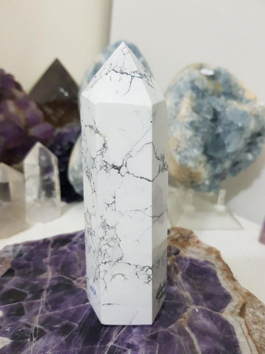 A polished White Howlite crystal generator that stands upright at approximately 14.5 centimetres tall and 5 centimetres wide